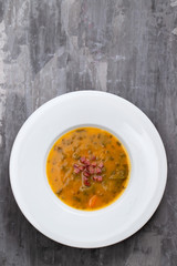 soup with smoked meat in white plate on ceramic dish