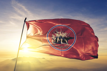 Sing Buri province of Thailand flag waving on the top sunrise mist fog