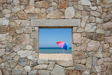summer beach with colorful umbrella through a window