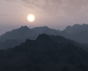 Rough mountains in mist at sunrise.