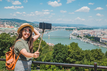 Fototapeta premium smiling cheerful woman in sunglasses taking selfie. budapest city on background