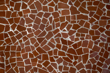 Decorative stone wall background with broken brown ceramics pieces stitched together by cement.