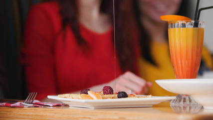A restaurant food. Serving pancakes on a plate. Pouring a syrup on pancakes