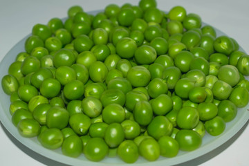green pea pod,green peas in a white bowl