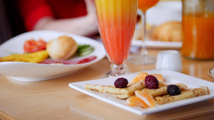 A restaurant food. Served pancakes on a plate. A table full of food.