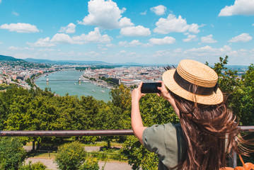 Fototapeta premium young woman taking picture with smartphone of old european city