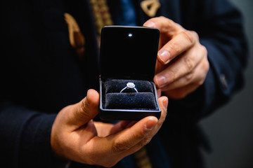 Real life proposal: Man holds an illuminated engagement ring - Blue bride ring with a big gem