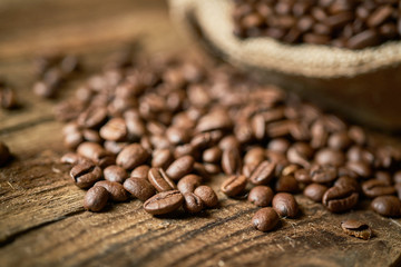 Ziarna kawy w jutowym worku na starych deskach © piotrszczepanek