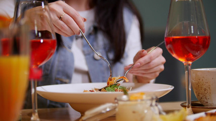 A woman in a restaurant eating pasta fettuccine
