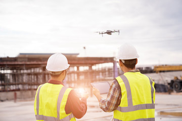 Construction concept of Engineer  working at construction Site with Drone over construction site.