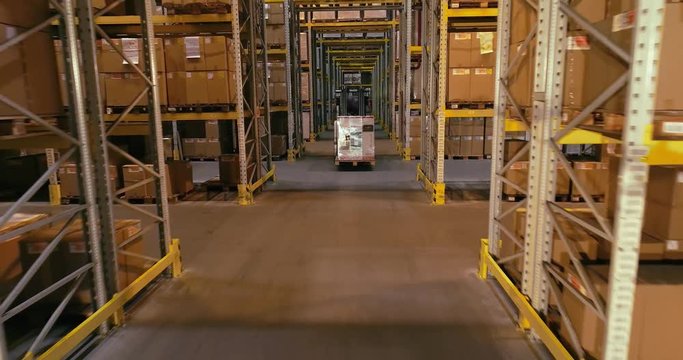 Modern forklift driving through the warehouse, active work in the warehouse of the plant