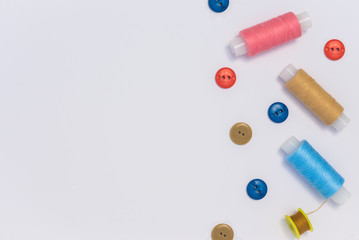 needlework, craft, sewing and tailoring concept - box with thread spools and buttons on table