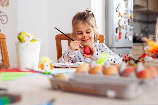 Cute little girl painting egg for Easter -