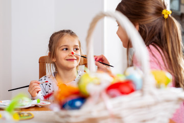 Happy easter! A beautiful child girl painting Easter eggs.