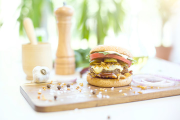 Closeup of delicious fresh homemade hamburger on wooden background.
