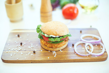 Delicious hamburger served on wooden planks. Closeup of delicious fresh homemade hamburger on wooden background.