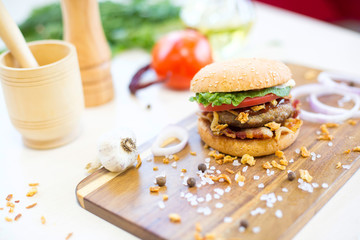 Fresh Burger with cheese, meat and vegetables. On wooden background.
