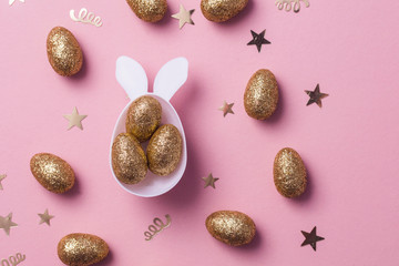 Gold glitter eggs in a white easter bunny egg shape with ears