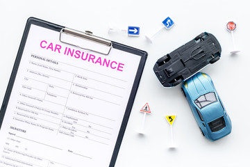 Car insurance concept with form, car toys on white background top view