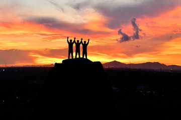 Fototapeta premium silhouette three men on peak mountain