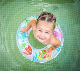 The child swims on an inflatable circle.