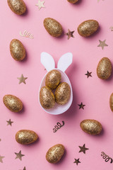 Gold glitter eggs in a white easter bunny egg shape with ears