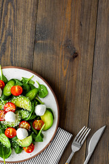 Vegetarian meal. Fresh vegetable salad on dark wooden background top view copy space