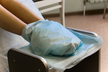 Pedicure. Legs are moistened with the cleaning means and enveloped by a cloth 