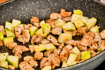 Meat and zucchini on frying pan
