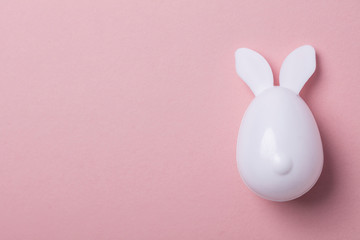 Easter egg with bunny ears on a pastel pink background