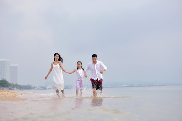 happy family of father, mother and daughter on the beach .Concept for  family holiday ,vacation ,insurance and summer.