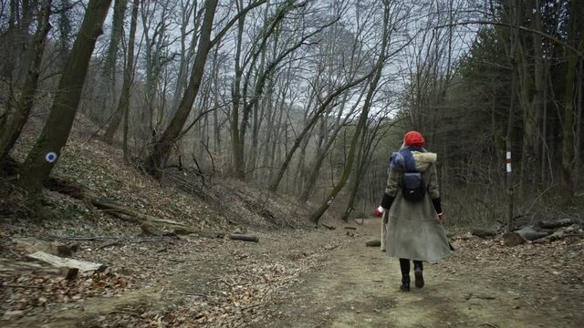 Young attractive woman with red hat wanders in forest
