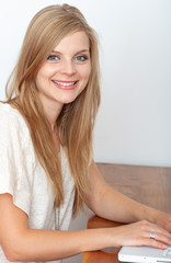 Naklejka premium Portrait of cheerful young woman with computer on her desk