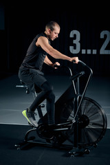 Fototapeta na wymiar Fitness male using air bike for cardio workout at Functional training gym.