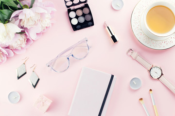 Beautiful cosmetics and flowers flat lay with note book, herbal tea on pastel background.