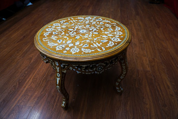 Antique coffee table with flower patterns. There are handcrafted mother of pearl inlays on the table.