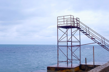 Lifeguard tower at empty waterfront beach in the off-season. Windy day and stormy sea.