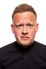 Close up portrait of a confident, blond, handsome young man wearing black shirt, isolated on white background