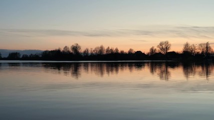 red sunset over the water of a village lake