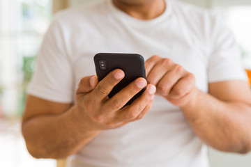 Close up of middle age man hands using smartphone at home