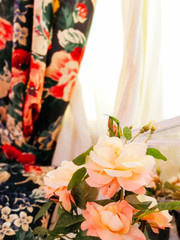 beautiful bouquet of flowers in a vase on the background of curtains and white tulle in the living room or bedroom.