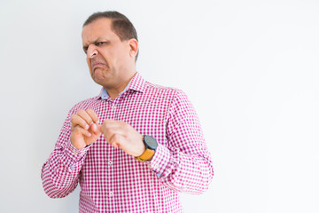 Middle age man wearing business shirt over white wall disgusted expression, displeased and fearful doing disgust face because aversion reaction. With hands raised. Annoying concept.