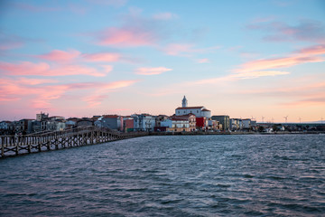 Fototapeta premium the panorama of Lesina and jatty on lake (lagoon) at sunset. Gargano National Park, Apulia, Italy