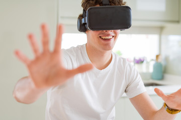 Young man having fun wearing virtual reality glasses at home