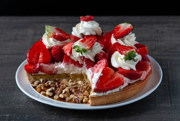 fresh delicious cream cake with strawberries on a plate