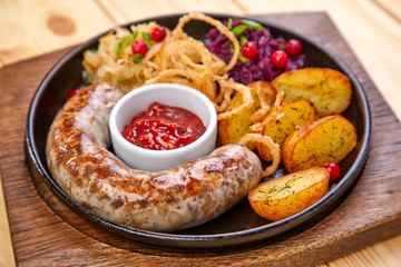 sausage with baked potatoes and salad on the wooden background