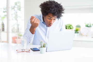 African American business man working using laptop annoyed and frustrated shouting with anger, crazy and yelling with raised hand, anger concept