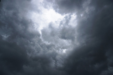 Dark, grim, stormy, rainy sky with rays of light. Scary hurricane clouds. Natural element. Stock Photo for your design