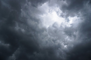 Dark, grim, stormy, rainy sky with rays of light. Scary hurricane clouds. Natural element. Stock Photo for your design