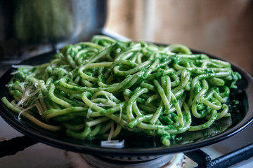 Spaghetti with green arugula sauce of garlic and olive oil, with grated melted cheese. 